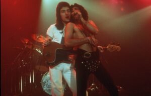 Queen actuando en concierto con Freddie Mercury vistiendo un leotardo negro en el Foro el 22 de diciembre de 1977 en Inglewood, California.  Crédito: Richard Creamer/Michael Ochs Archives/Getty Images